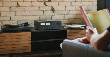 L’amplificateur NAD C 3030 au design néo-rétro, installé dans un système Hi-Fi avec platine vinyle et VU-mètres analogiques.