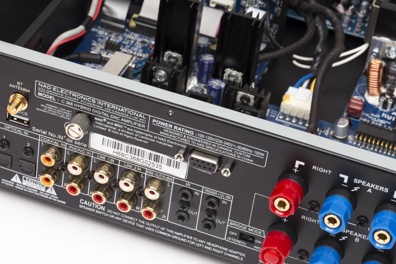 Vue arrière et interne de l’amplificateur NAD C 368, mettant en évidence la connectique complète, les borniers enceintes et l’architecture hybride pensée pour l’évolutivité.