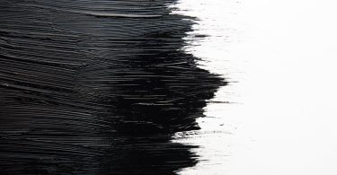 Contraste visuel entre une texture noire profonde et une surface blanche lumineuse, illustrant le débat esthétique noir ou argent en Hi-Fi.