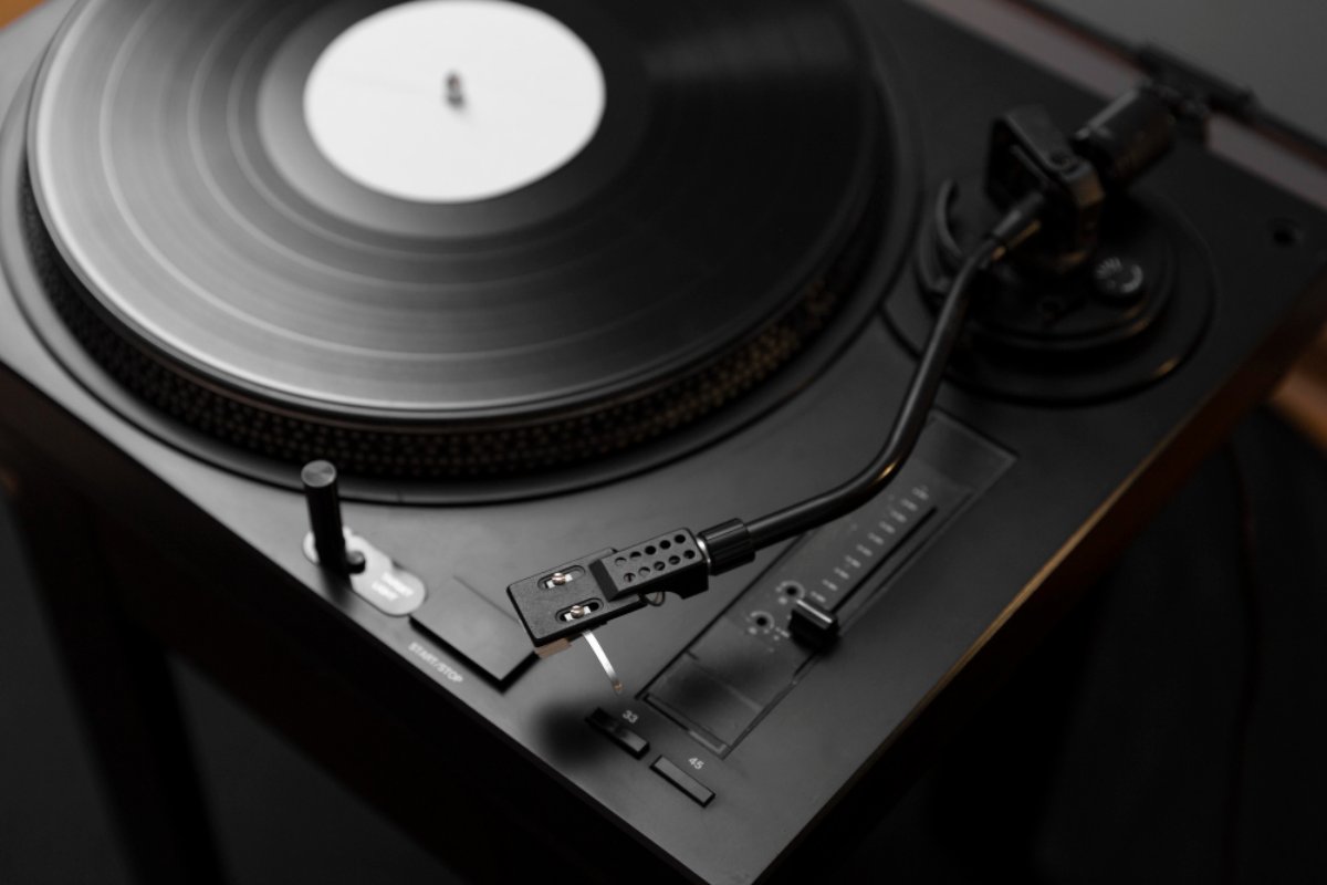 Platine vinyle noire avec bras de lecture en fonctionnement, incarnant l’élégance discrète et l’esthétique immersive de la Hi-Fi sombre.