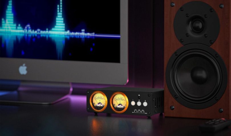 Douk Audio L3 avec double VU-mètre analogique sur un bureau audio relié à des enceintes et un ordinateur