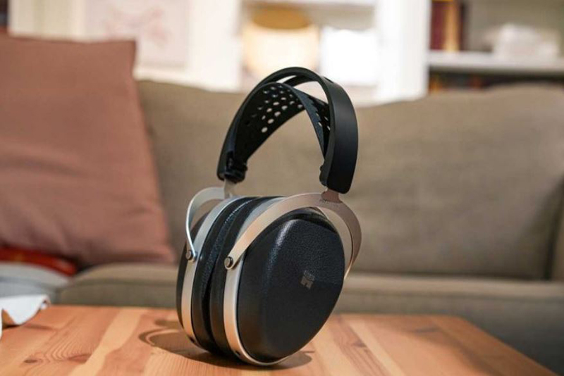 Casque HIFIMAN AUDIVINA LE posé sur un bureau moderne avec accessoires tech.