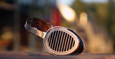 HIFIMAN HE1000 V2 posé sur table moderne dans un salon lumineux