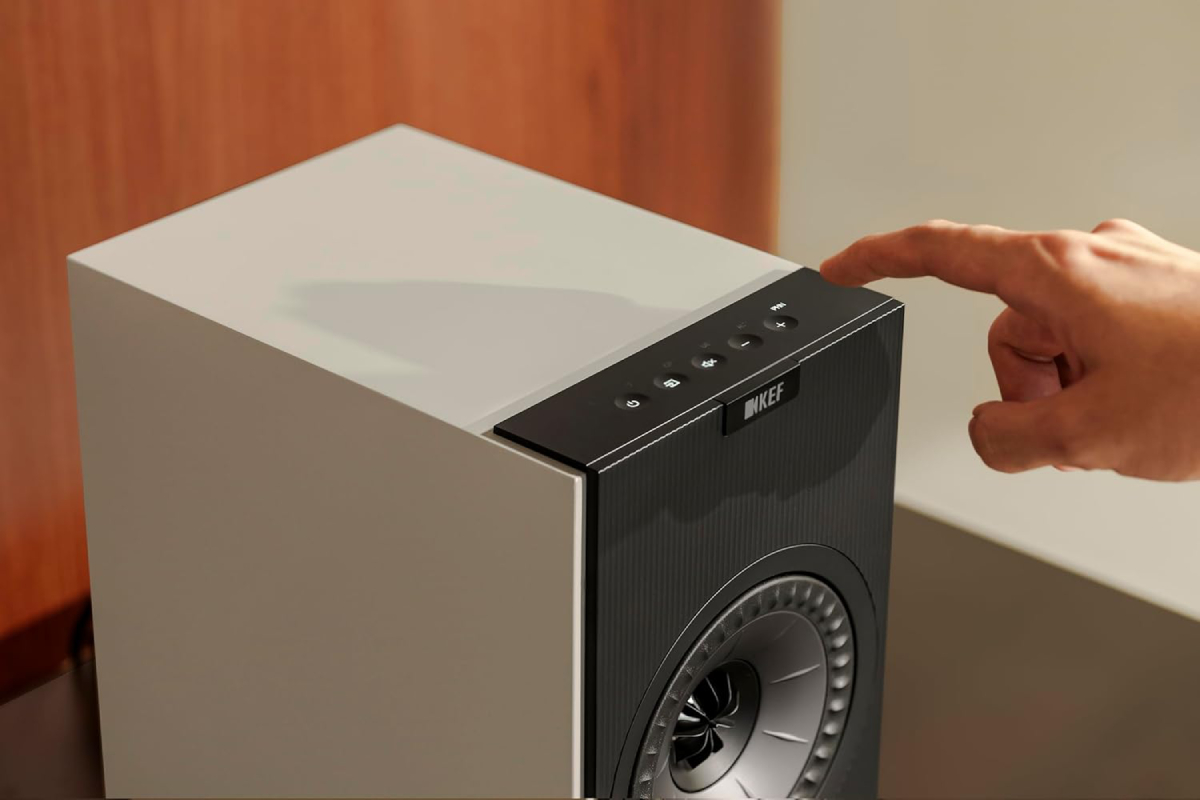 KEF Coda W enceinte active bibliothèque posée sur meuble en bois dans un intérieur moderne minimaliste