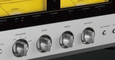 Gros plan sur la façade argentée de l'amplificateur Luxman L-100 Centennial montrant les réglages de tonalité, les vumètres jaunes éclairés et l'affichage numérique rouge.
