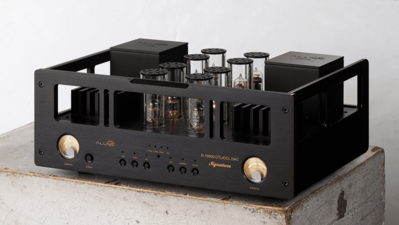 DAC haut de gamme Allnic Audio D-15000 Signature avec châssis noir, tubes apparents protégés par des cylindres en verre et VU-mètres analogiques éclairés.