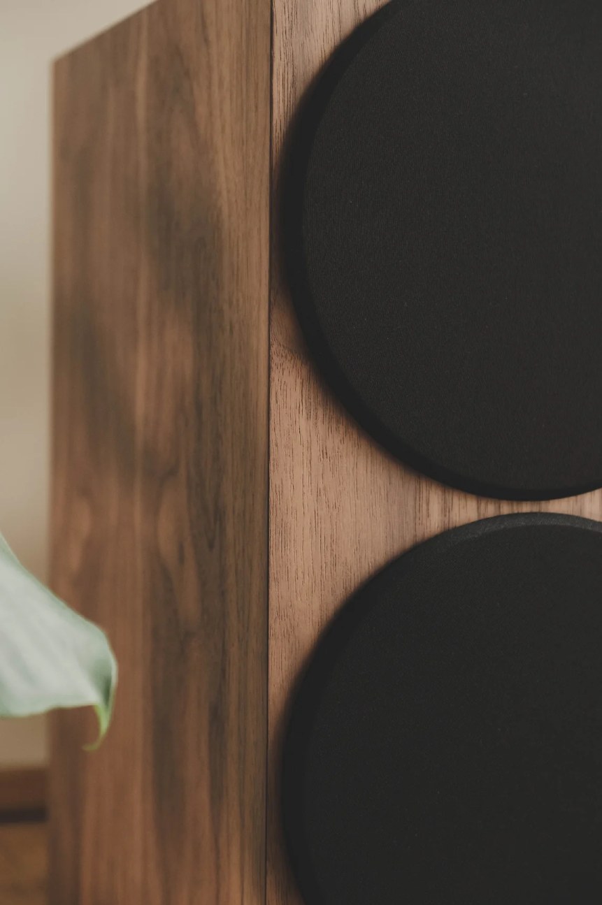 Vue rapprochée du grain bois noyer véritable de l'enceinte Buchardt S400 MK3 avec sa grille magnétique en tissu noir.