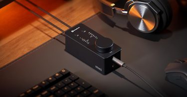 Le Fosi Audio SK02 est posé sur un bureau avec un casque audio branché à proximité