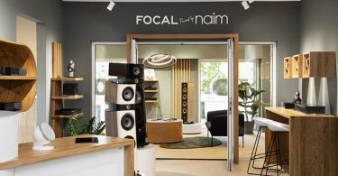Showroom luxueux exposant des enceintes colonnes Focal Sopra et Utopia avec électronique Naim Audio dans un espace de démonstration moderne.