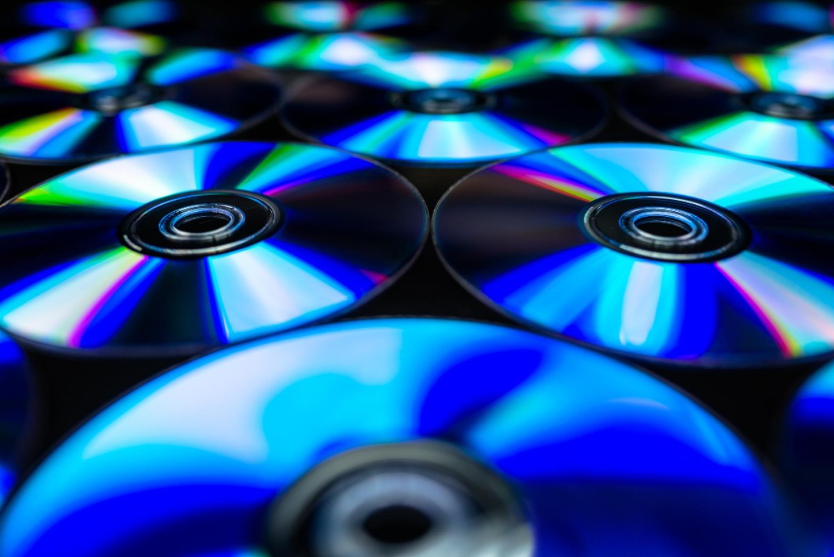 Un gros plan détaillé sur les reflets arc-en-ciel d'un compact disc, montrant une texture subtile qui suggère des structures de données de taille micron.