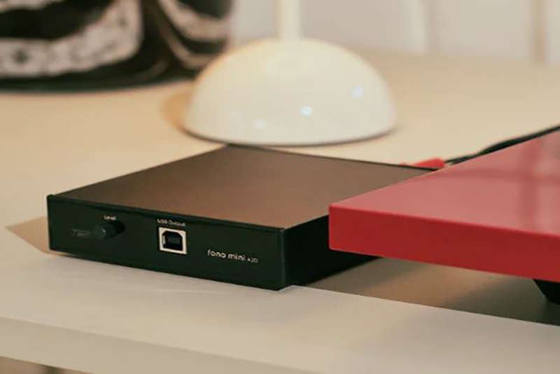 Rega Fono Mini A2D MK2 sur une table vintage avec vinyles