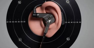 Écouteur intra-auriculaire Brise Audio IBUKI en titane Grade 5 avec revêtement PVD, positionné sur oreille de mesure pour test acoustique