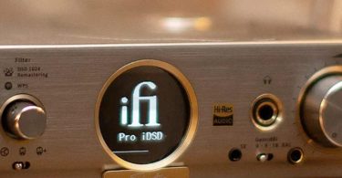 Vue rapprochée de la façade d'un DAC iFi Audio Pro iDSD Signature montrant l'écran circulaire avec logo, le badge Hi-Res Audio et les connecteurs jack pour casque.