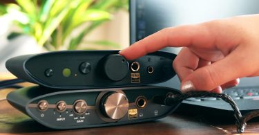 Setup hi-fi de bureau avec le iFi Zen Air DAC 2 en finition midnight blue, sorties casque 6,3 mm et 4,4 mm balanced visibles avec logo Hi-Res Audio, posé sur un bureau bois en compagnie d'un ordinateur portable et d'un casque audio