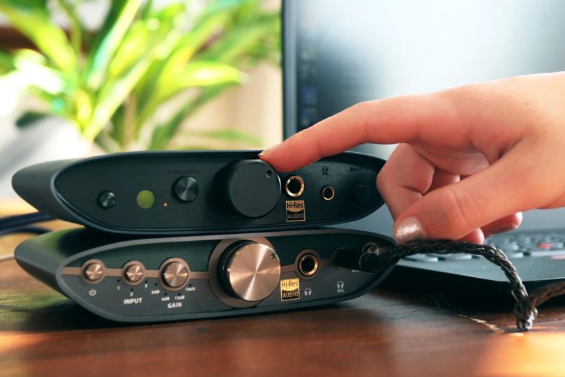 Setup hi-fi de bureau avec le iFi Zen Air DAC 2 en finition midnight blue, sorties casque 6,3 mm et 4,4 mm balanced visibles avec logo Hi-Res Audio, posé sur un bureau bois en compagnie d'un ordinateur portable et d'un casque audio