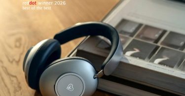 Casque audio Loewe Leo posé sur un livre en bois, avec le badge officiel Red Dot Winner 2026 Best of the Best