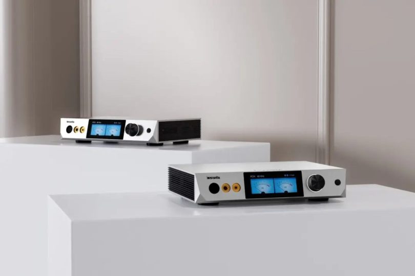 Les deux DAC-amplis casque desktop Luxsin X8 et X9 posés sur des socles blancs, avec écran tactile 4 pouces affichant des VU-mètres analogiques et sortie casque symétrique XLR
