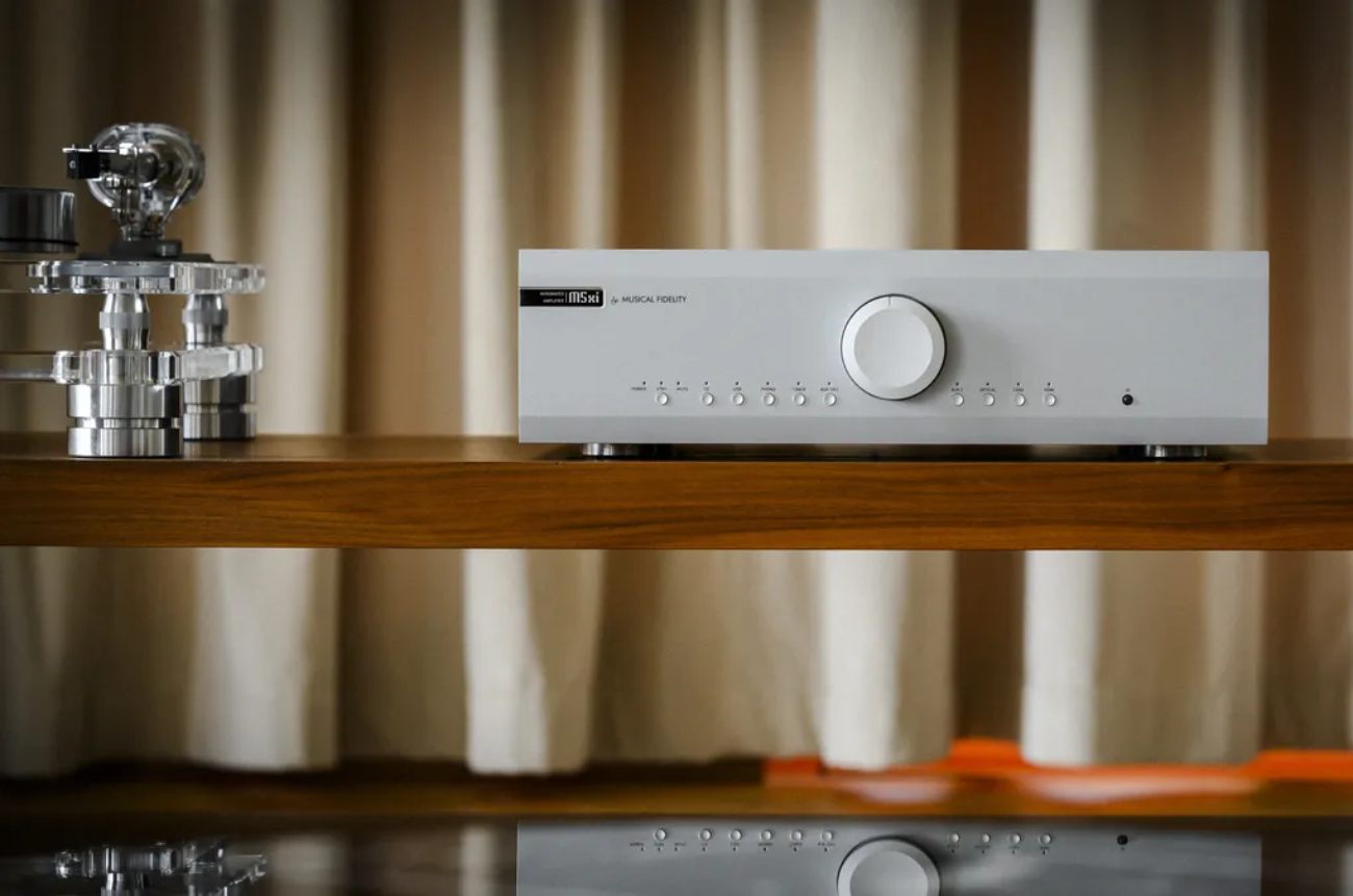 Amplificateur intégré Musical Fidelity M5xi en finition silver vue de face, avec ses dix boutons de sélection d'entrée (Power, Standby, Mute, CD, USB, Phono, Tuner, AUX, Balance, Optical, Coax, HDMI), son large bouton de volume central et son logo m5xi gravé sur la façade aluminium brossée