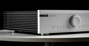 Amplificateur intégré Musical Fidelity M6xi en finition argent, avec large bouton de volume central et dissipateurs latéraux en aluminium extrudé, posé sur une table ronde