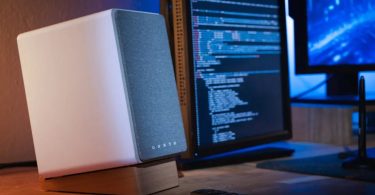 Enceinte active Onkyo Creator Series blanche sur bureau avec écran de développeur en arrière-plan