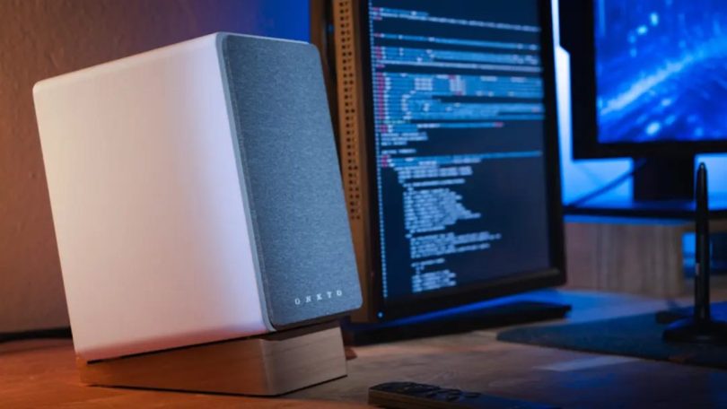 Enceinte active Onkyo Creator Series blanche sur bureau avec écran de développeur en arrière-plan