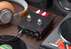 Le préampli Fosi Audio BOX X4 est présenté avec un vinyle en lecture dans un environnement audio chaleureux.