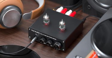 Le préampli Fosi Audio BOX X4 est présenté avec un vinyle en lecture dans un environnement audio chaleureux.