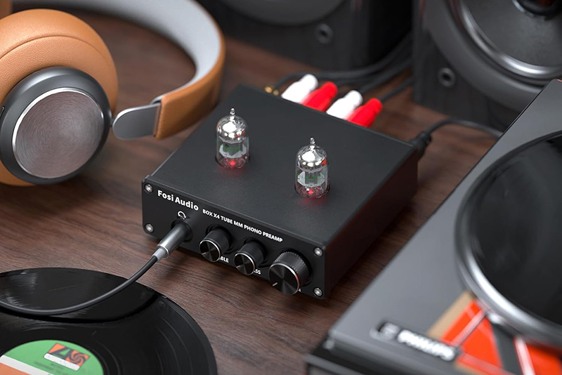 Le préampli Fosi Audio BOX X4 est présenté avec un vinyle en lecture dans un environnement audio chaleureux.