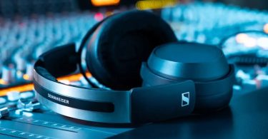 Casque studio fermé Sennheiser HD 480 PRO avec arceau aluminium brossé et coussinets cuir, posé sur une console de mixage en éclairage ambiant bleu et orange