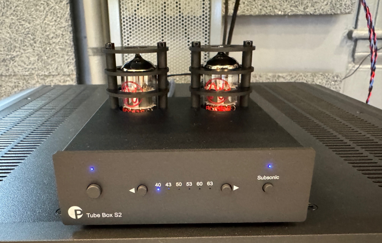 Préampli phono Pro-Ject Tube Box S2 en fonctionnement avec ses deux tubes ECC83 éclairés et réglages de gain activés en façade.