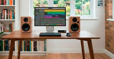 Enceintes actives Vulkkano A4 ARC MKII en finition bois sur un bureau avec écran et DAC audio