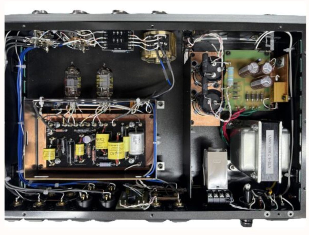 Vue intérieure du préamplificateur à tubes Air Tight ATC-6 capot ouvert montrant à gauche les deux doubles triodes 12AT7 sur leurs supports céramique au-dessus du PCB principal sur substrat cuivre avec condensateurs PP-film jaunes et résistances film de précision, câblage point-à-point en fil cuivre haute pureté multicolore, à droite la section alimentation séparée avec transformateur torique ATE-6 100V/120V, condensateurs électrolytiques noirs de filtrage et PCB régulation
