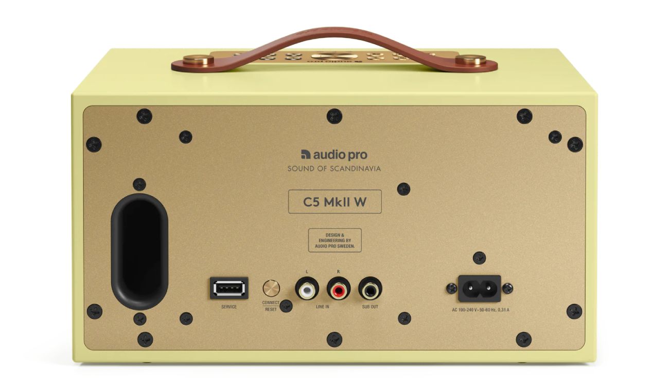Vue arrière officielle de l'enceinte multiroom Audio Pro C5 MkII W Classic Yellow révélant la plaque arrière en métal laiton brass avec marquage Design and Engineering by Audio Pro Sweden Sound of Scandinavia, évent de bass-reflex ovale noir à gauche, connectique complète port USB-A service bouton Connect Reset entrées RCA Line In stéréo sortie Sub Out pour caisson de basses et prise IEC alimentation universelle 100-240 volts