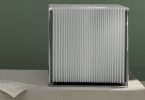 Amplificateur de puissance Burmester 259 Reference Line en finition argent, châssis cubique aux ailettes de dissipation verticales et logo Burmester gravé sur le capot, posé sur un socle béton