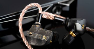 Campfire Audio Chimera, écouteur intra-auriculaire flagship en finition noir PVD avec faceplate Damascus carbone-laiton aux motifs uniques et nozzle en laiton, présenté avec son câble ALO Audio Valence-6 cuivre tressé