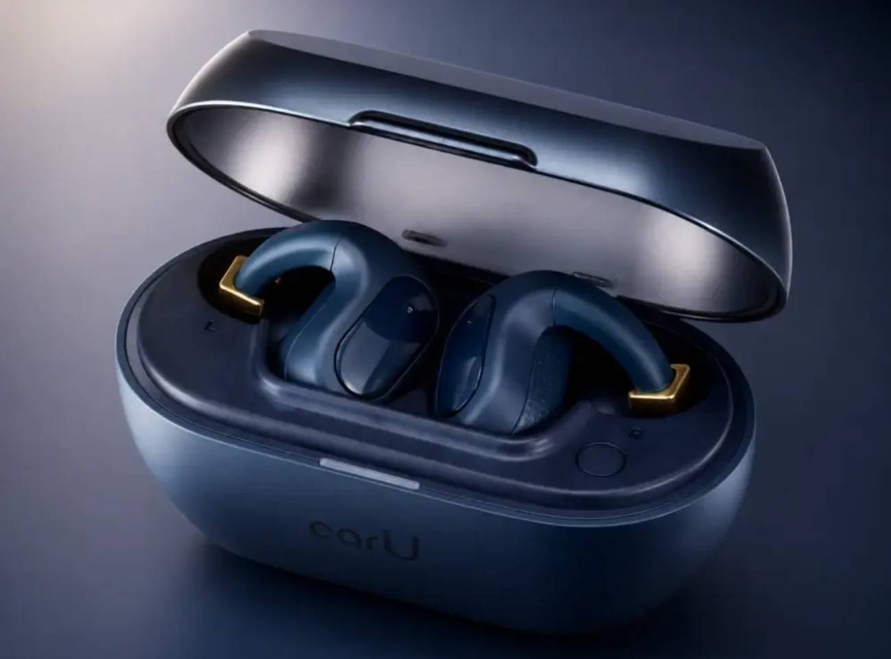 Visuel produit officiel Casio earU ER-100 en finition Navy Black, boîtier de charge ovale ouvert avec logo earU gravé en façade, deux écouteurs open-ear cuff visibles dans leurs logements L et R avec charnières dorées métallisées, mise en scène studio sur fond gradient bleu nuit