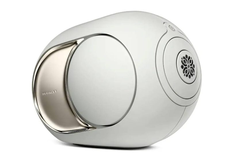 Enceinte connectée Devialet Phantom Ultimate en finition Light Pearl, vue de trois quarts montrant la forme sphérique signature, le woofer latéral à dôme ABS avec flasque PVD chromée et la grille du tweeter inspirée des jardins à la française du XVIIIe siècle, désormais compatible Qobuz Connect via la mise à jour DOS3