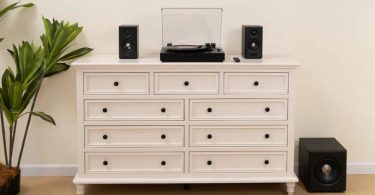 Système 2.1 Edifier S355DB en finition noire installé sur commode blanche avec deux enceintes satellites encadrant une platine vinyle, et subwoofer 8 pouces sans fil 5.8 GHz posé au sol à droite, dans un salon contemporain lumineux avec plante verte