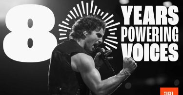 Visuel officiel de la campagne 80 ans de JBL en noir et blanc avec l'ambassadeur Benson Boone en performance scénique chantant dans un micro, signature 80 YEARS POWERING VOICES et logo JBL orange