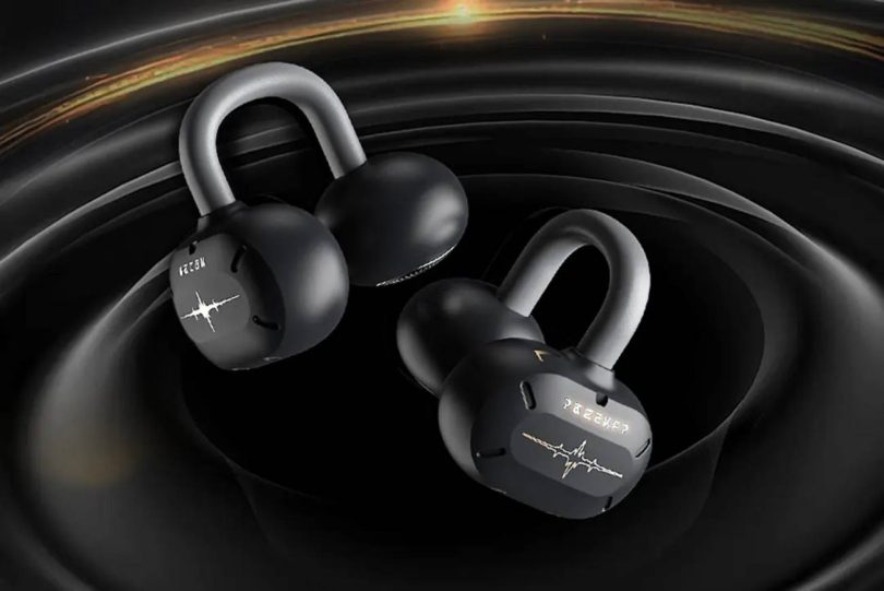 Paire d'écouteurs OWS ear-clip Moondrop U.C.T.S. en finition noire édition collaboration Wuthering Waves, vue rapprochée sur fond noir sculpté avec accents dorés, branding Rover masculin et féminin visible sur les capsules acoustiques, C-bridge en silicone à mémoire de forme et alliage titane