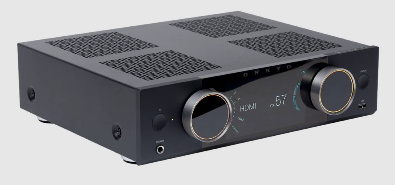 Amplificateur Onkyo Muse en finition noire vu de trois quarts, écran couleur affichant la sélection de source HDMI avec les entrées TV et COAX et le niveau de volume 57, logo ONKYO, deux molettes rotatives, touche DISPLAY, port USB frontal, prise casque jack 6,35 mm et capot ajouré au motif San Kuzushi