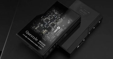 Questyle M18i MAX, DAC ampli casque portable noir, écran OLED affichant 384000 USB2.0 PCM, gain L, posé sur fond ardoise à côté de son packaging premium imprimé du PCB Questyle CMA SiP Inside et de la mention Mobile Headphone Amplifier with DAC