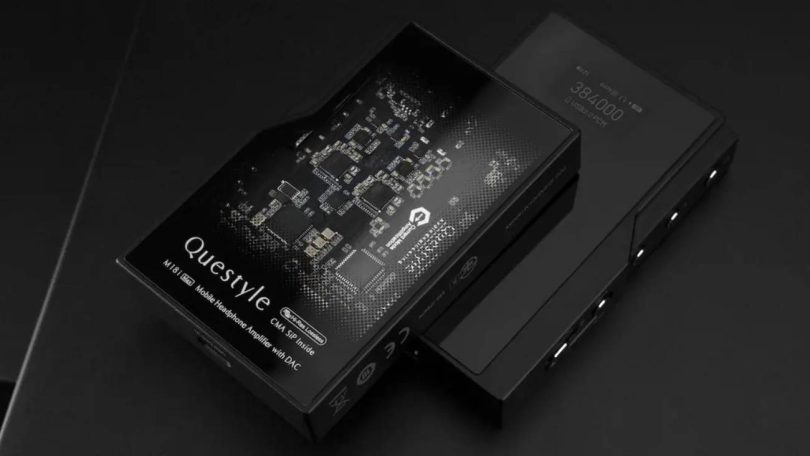 Questyle M18i MAX, DAC ampli casque portable noir, écran OLED affichant 384000 USB2.0 PCM, gain L, posé sur fond ardoise à côté de son packaging premium imprimé du PCB Questyle CMA SiP Inside et de la mention Mobile Headphone Amplifier with DAC