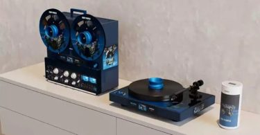 Revox Deep Purple Limited Edition : magnétophone à bande B77 MK III en habillage bleu nuit avec bobines décorées SPLAT!, platine vinyle T77 et enceinte sans-fil STUDIOMASTER A200 cylindrique posés sur un meuble blanc minimaliste, série limitée signée par les membres de Deep Purple
