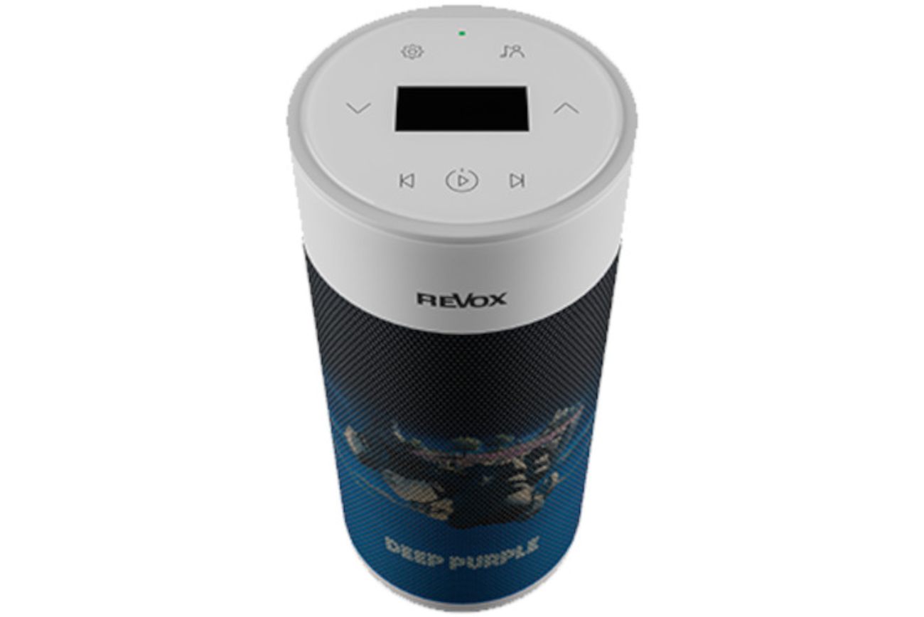 Vue de trois-quarts vers le haut de l'enceinte sans-fil active Revox STUDIOMASTER A200 Deep Purple Limited Edition cylindrique avec calotte blanche dévoilant le panneau de commande tactile complet (écran OLED, boutons settings, multiuser, navigation haut/bas, précédent/lecture/suivant), grille acoustique habillée du visuel SPLAT! représentant des îlots rocheux marins sur fond bleu nuit, logo REVOX en haut et inscription DEEP PURPLE en bas de la grille