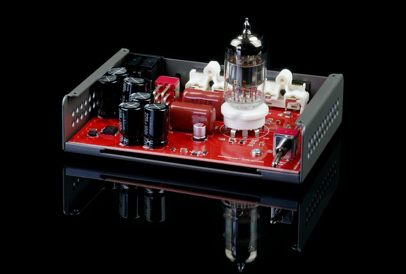 Vue intérieure du Schiit Buf capot retiré montrant le PCB rouge signature Schiit avec marquage Coherence Tube Buffer, tube 6N1P sur support céramique blanc, condensateurs Nichicon 220 microfarads 100 volts de l'alimentation linéaire haute tension, condensateur film de couplage rouge et switch toggle de gain en façade