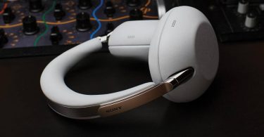 Sony 1000X The ColleXion en finition Platinum White vu de profil, montrant le bandeau métallique poli, les charnières chromées et les coussinets en cuir épais qui caractérisent le repositionnement luxe du casque pour les 10 ans de la série 1000X