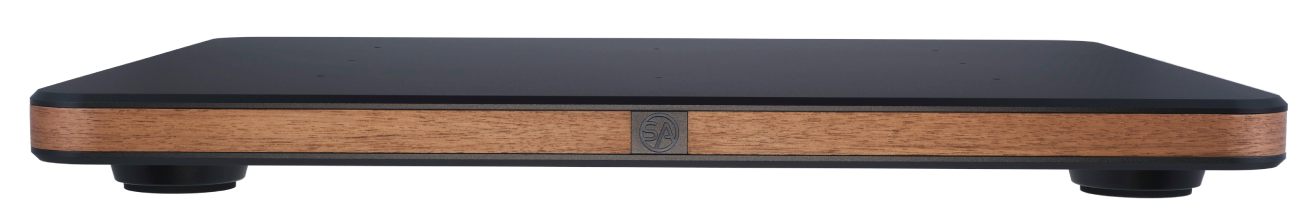 Vue de profil panoramique de la Stack Audio AUVA Platform isolée sur fond blanc, révélant l'architecture sandwich à trois étages : plaque aluminium anodisé noir supérieure, liseré central en placage noyer estampillé du logo SA, plaque aluminium inférieure, et deux pieds CSA Custom Silicone Absorber visibles aux extrémités