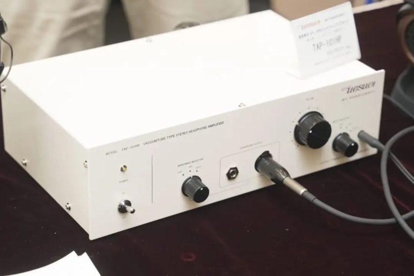 Amplificateur casque Uesugi TAP-101HP en chassis blanc avec interrupteur d'alimentation, sélecteur d'impédance LOW MID HIGH, sortie casque jack 6.3 mm et XLR 4 broches, et boutons de volume, présenté au Spring Headphone Festival 2026 de Tokyo