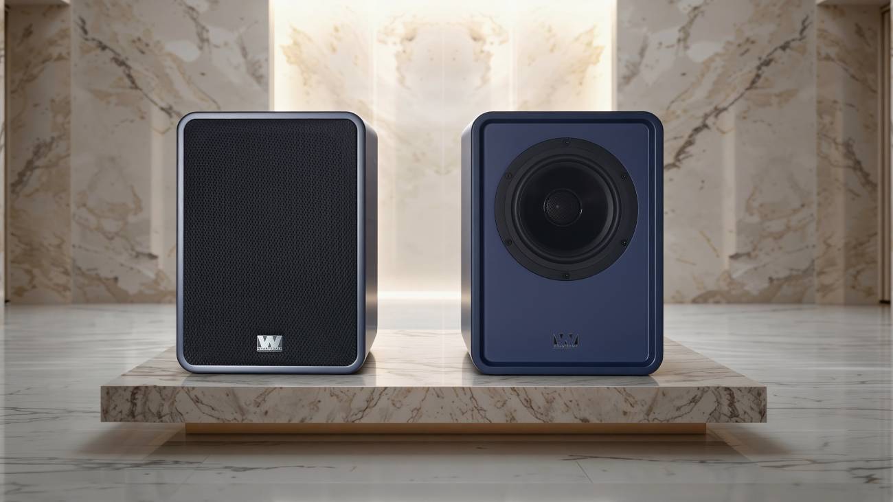 Paire enceintes Wharfedale Denton 1S finition bleu mat sur socle de marbre, exemplaire de gauche avec grille magnétique noire et badge Heritage Series argent, exemplaire de droite sans grille montrant le driver coaxial 2 voies.